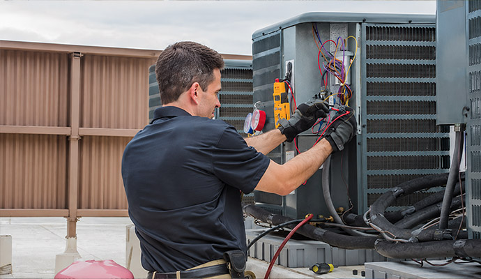 A technicians performing critical maintenance on an HVAC unit to improve efficiency