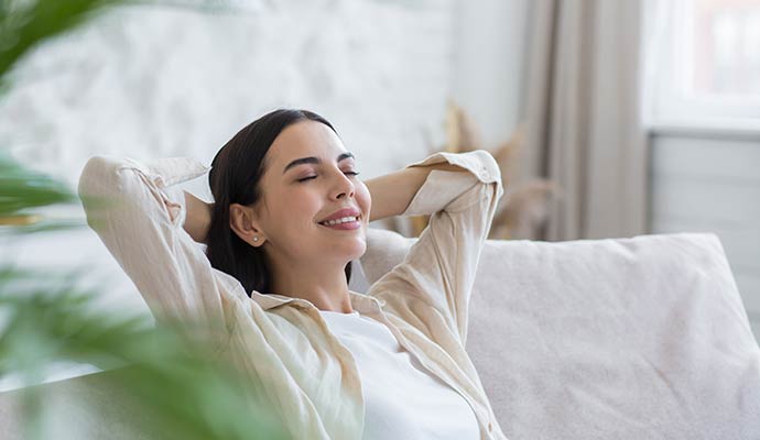 A relaxed woman sitting back on a comfortable couch