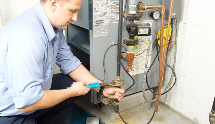 HVAC technician repairing boiler system pipe